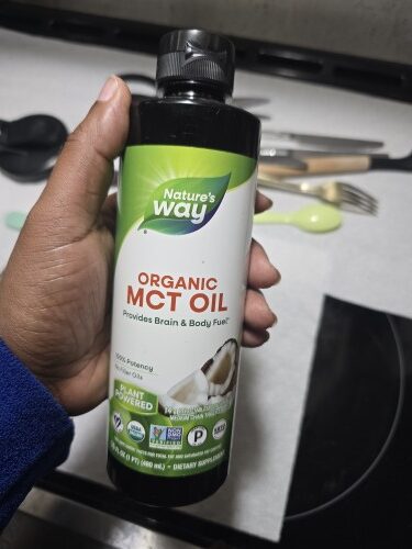 Me holding a bottle of Nature’s Way Organic MCT Oil